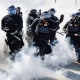 Police officers use smoke grenades outside on the highway