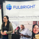 A woman speaks to another woman across a table at a Fulbright Program information booth