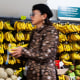 A shopper in front of a display of bananas.