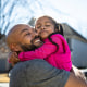 Father holding young daughter outdoors
