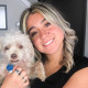 Caroline Dias Goncalves holds a dog and smiles for a portrait
