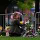 A woman places flowers at a makeshift memorial for victims of an attack outside of the Boulder County Courthouse Tuesday, June 3, 2025, in Boulder, Colo. 