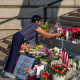 A woman lays flowers at a makeshift memorial.