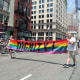 People march with a rainbow sign that says "Dignity"