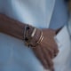 A woman wearing Cartier and Van Cleef & Arpels bracelets.
