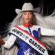 Beyonce sitting on a white horse wearing a sash that says "Cowboy Carter" and waving the American flag