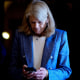 Lisa Murkowski looking down at her phone