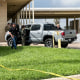 Officials work the scene of a shooting outside, a truck is parked outside with agents surrounding it