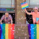 Spectators throw confetti from a third-floor apartment window
