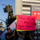 A person holds a sign that says "Trans Rights Are Human Rights"