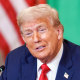 Donald Trump speaks while seated at a table