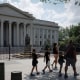 Pedestrians walk past the Treasury building in Washington, D.C.