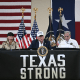 President Donald Trump and first lady Melania Trump with Texas governor Greg Abbott sitting at a table that reads, "Texas Strong"