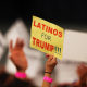 A supporter holds a sign that reads " Latinos for Trump"