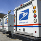 Image: Row of USPS delivery trucks