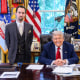 Economist E.J. Antoni stands, left, and President Donald Trump sits at his desk in the Oval Office