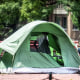 People walk past tents at a homeless encampment