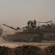 Israeli soldiers stand on top of a tank 