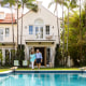 Senior couple walking by swimming pool in back yard