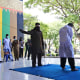 An official uses a rattan cane to whip a man convicted of violating Islamic law by hugging and kissing 