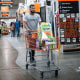 A shopper pushes a cart in a Home Depot store