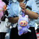 A woman holding a purple Labubu