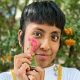 Catalina "Xochitl" Santiago holds a pink flower near her cheek