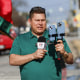 Mario Guevara holding a microphone and an iPhone via a tripod