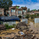 A Kashmiri man stands near his partially submerged house