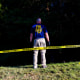 An FBI agent stands in an area behind Utah Valley University where evidence was collected