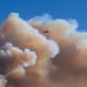 A helicopter flies above clouds of smoke