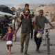 People walk on a road with their belongings