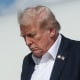 Donald Trump walks down the stairs of a plane outside