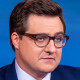 Chris Hayes; A Border Patrol agent walks through a cloud of tear gas.