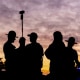 Law enforcement stand outside during a curfew outside an Immigration and Customs Enforcement (ICE) processing facility.