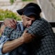John Middleton and his twin brother, James, embrace on a porch bench