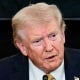 Donald Trump speaks while seated at a table