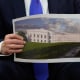 President Donald Trump holds an artist's rendering of the new White House ballroom on Oct. 22, 2025.