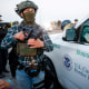 Boarder Patrol agent holds a gun.