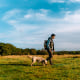 Young Asian man walking in nature with his dog.