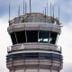An American Eagle plane takes off near the air traffic control tower.