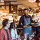 Waiter serving food to customers during party in restaurant.