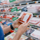 Man Checks Price of Ground Beef at Supermarket.