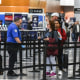 Image: Travelers make their way through a security line