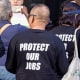Protesters wearing "Protect our Jobs" t-shirts.
