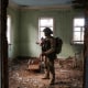 Ukrainian serviceman hides from a Russian combat drone in a building damaged by Russian military strike in the frontline town of Kostiantynivka
