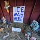 An "ICE WAS HERE" sign over an empty manger at a Nativity scene 