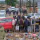 Residents wathch as South African Police Service (SAPS) officers gather at the scene of an attack at a tavern in Bekkersdal on Dec. 21