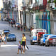 A woman with a girl passes a street in Havana