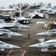 A US Navy officer walks past fighter jets parked on the flight deck of the Nimitz-class aircraft carrier USS Abraham Lincoln